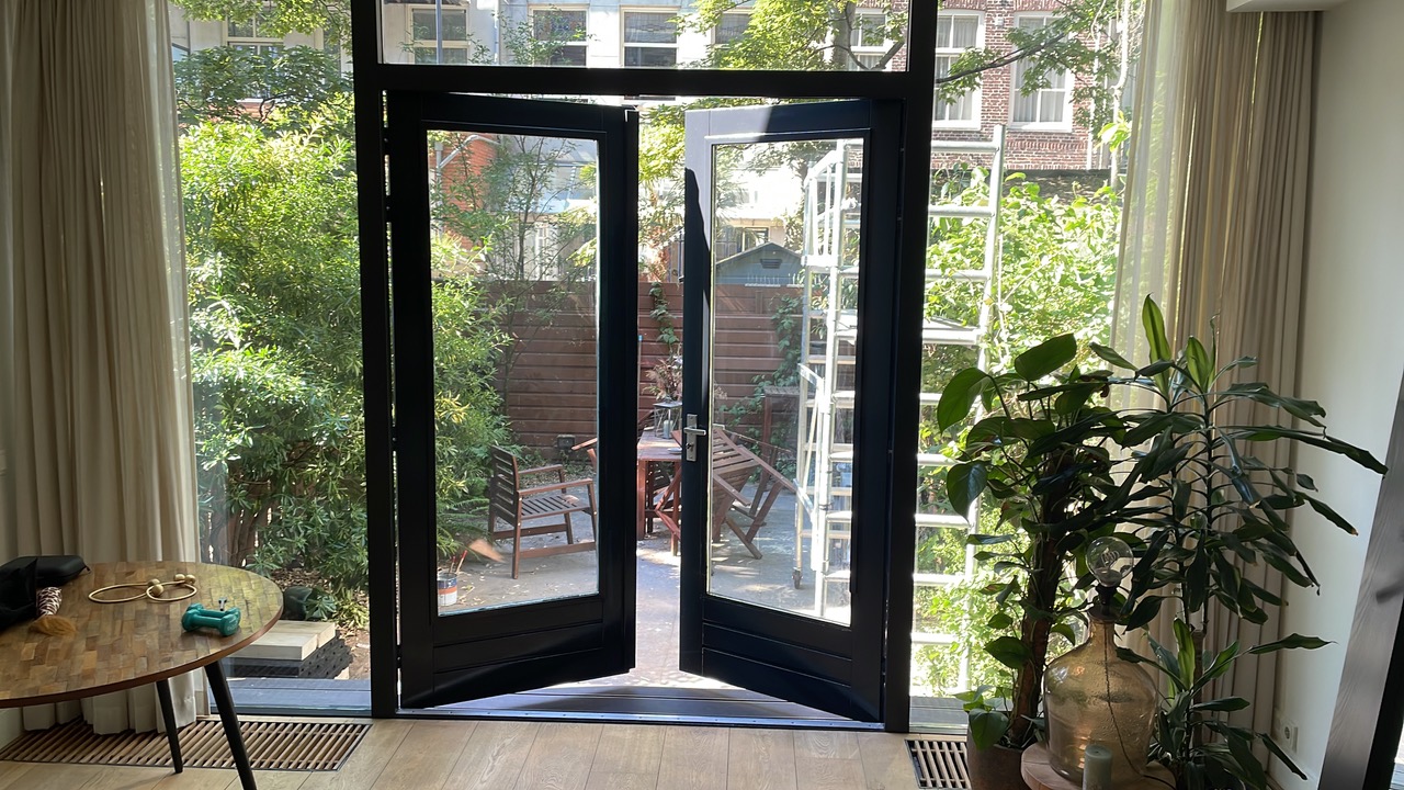 Zwarte deuren en kozijnen aan de binnenzijde van een woonkamer
