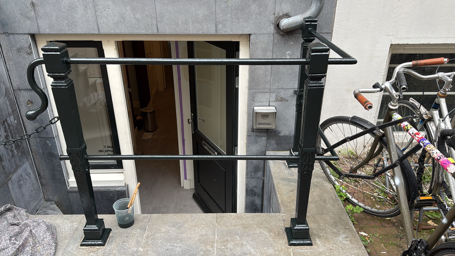 Donker geschilderd hekwerk bij de souterrainingang aan de Lange Leidsedwarsstraat in Amsterdam